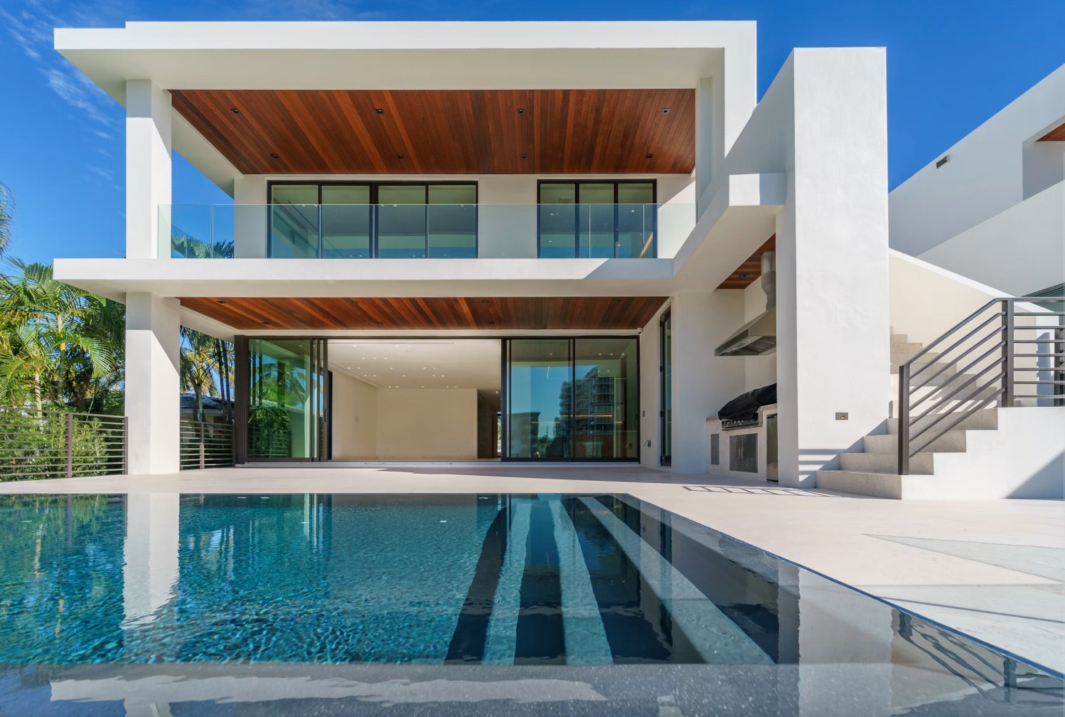 Villa moderna con piscina alargada de agua clara, terraza y techos de madera